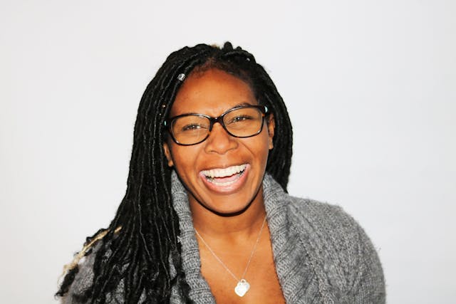 woman smiling with glasses and dredlocks